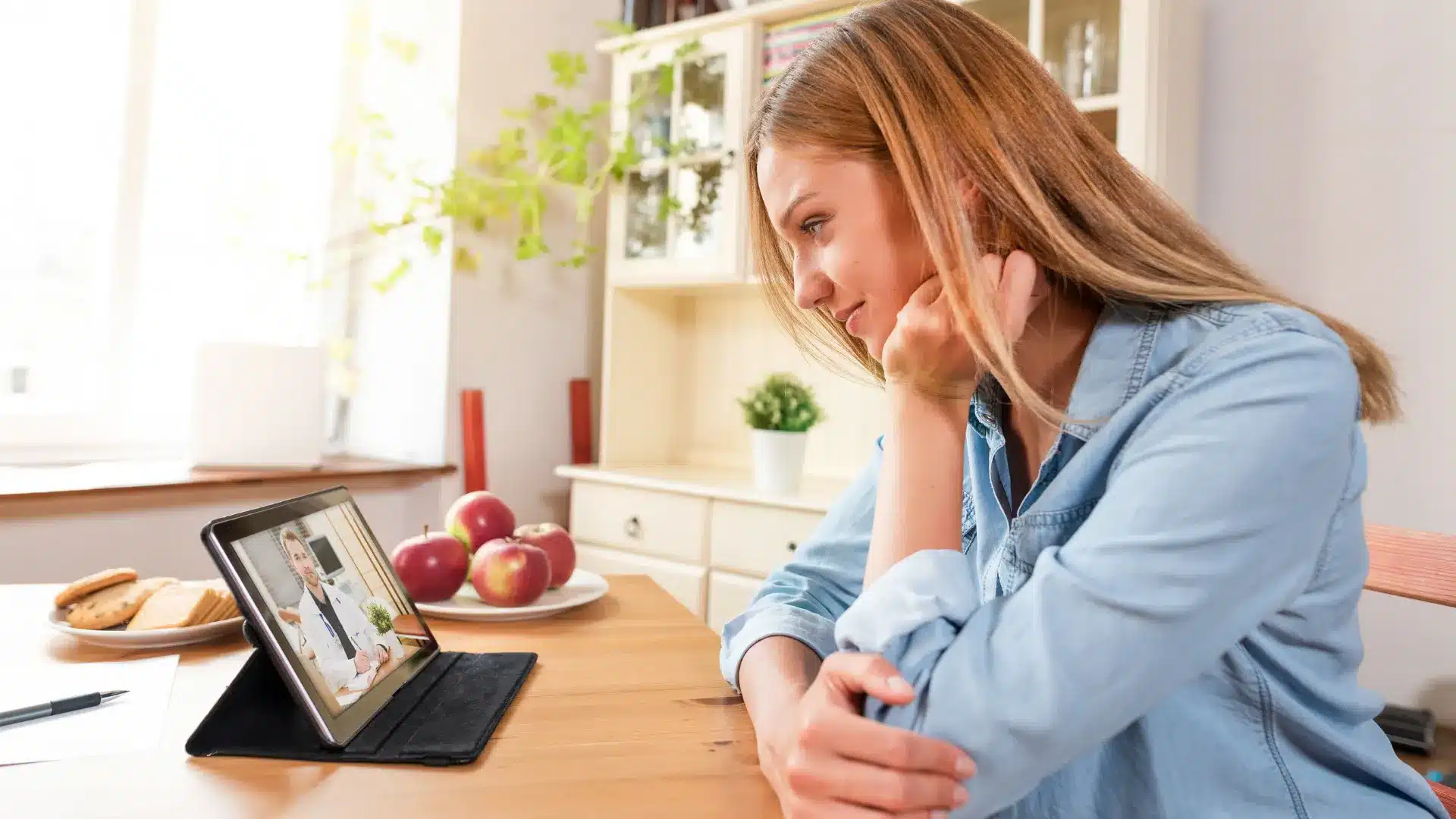 A patient at home having a telehealth consultation on a laptop